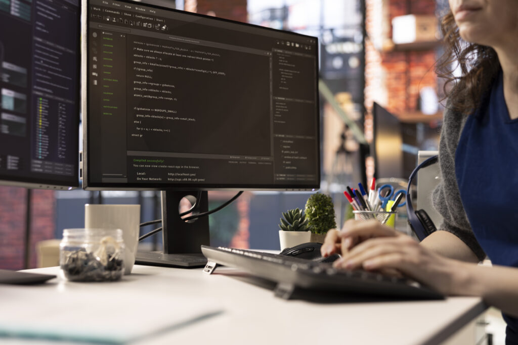 technician looking at ui on computer monitor and executing programming code